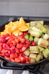 Rhubarb, strawberry and orange in a pan for making homemade jam