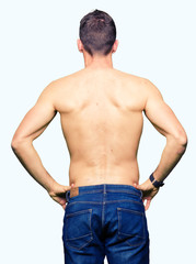 Fototapeta premium Handsome shirtless man showing nude chest standing backwards looking away with arms on body