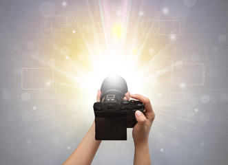 Naked hand taking picture with digital camera and glowing flash concept