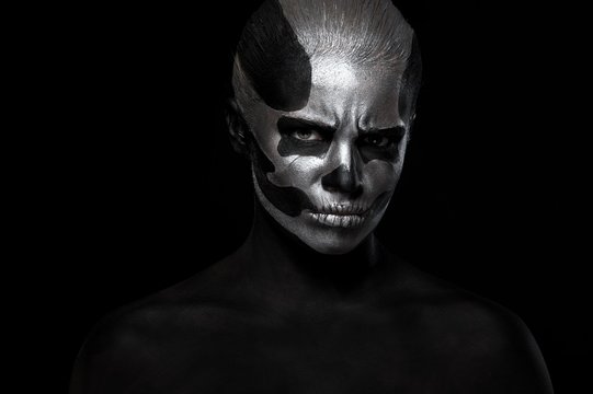 Halloween. Woman in day of the dead mask skull face art. Halloween face art on black background. Halloween make up.
