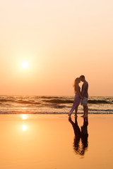 beautiful young couple posing at sunset in the sea