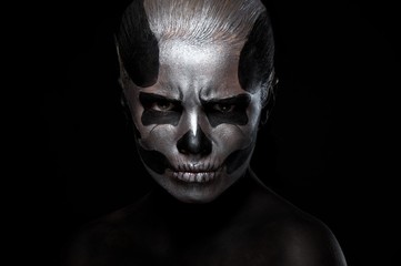 Halloween. Woman in day of the dead mask skull face art. Halloween face art on black background. Halloween make up.