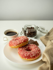 Różowy donut z posypką. Kawa i czekolada. Widok z góry, jasne tło. © PhotoHunter