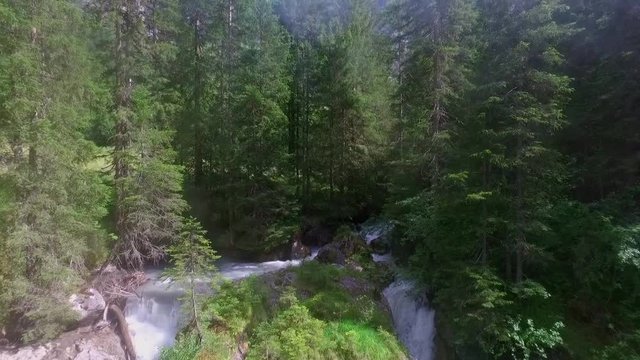 Aerial shot of double waterfall in the nature between high fir trees in summer.
