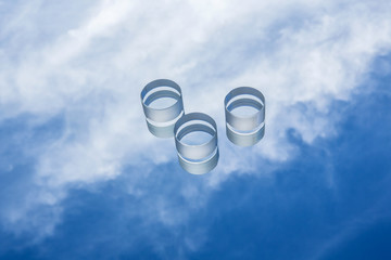 Flat cylindrical optical glass details against a blue sky with clouds