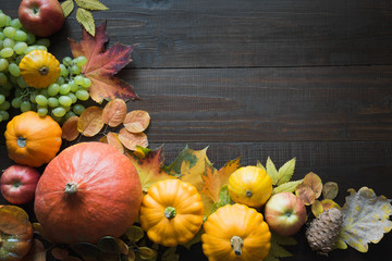 Still life of pumpkin and colorful maple leaves on wooden board with space for text. Fall pattern. Top view. Thanksgiving Day