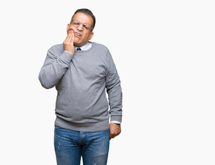 Fototapeta premium Middle age bussines arab man wearing glasses over isolated background touching mouth with hand with painful expression because of toothache or dental illness on teeth. Dentist concept.