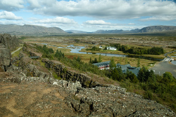 Fototapeta na wymiar Panoramic Scenic View On A Winding River, Valley, Farmhouses And Mountains In Iceland