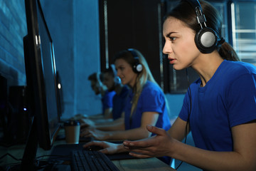 Group of people playing video games in internet cafe