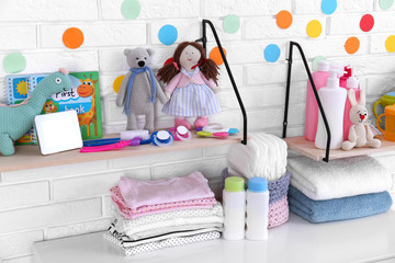 Baby accessories near white brick wall in nursery room