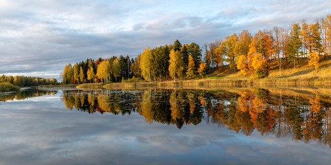 wonderful autumn landscape with gorgeous and colorful trees by the water, beautiful reflections in the water