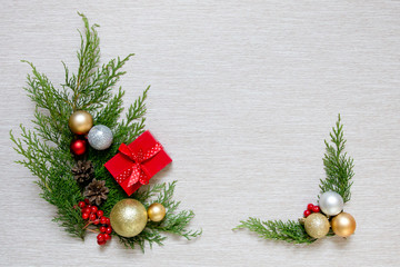 Green branches and Christmas balls. Christmas decor on a light background. New Year's gift in a small red box.