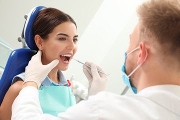 Professional dentist working with patient in clinic