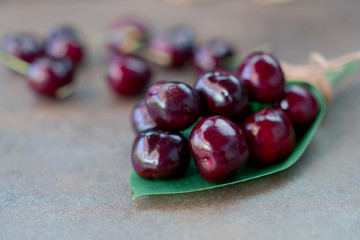 Fresh organic cherries on green leaf