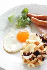 Homemade banana and chocolate waffle with sunny side up egg