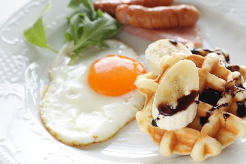Homemade banana and chocolate waffle with sunny side up egg