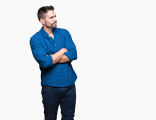 Young handsome man over isolated background smiling looking to the side with arms crossed convinced and confident