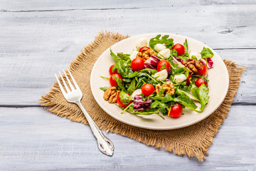 Fresh salad with arugula, radicchio, tomato cherry, baby mozzarella, walnuts