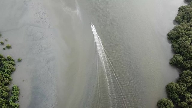Fishing boat move towards sea from mangrove tree forest at Kuala Juru, Penang.