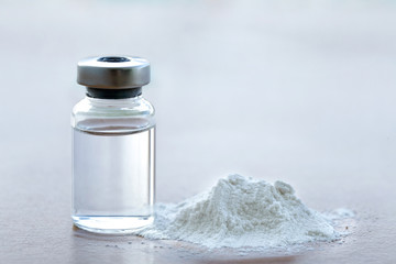 Vial of vaccine with drug powder on white background.GHB