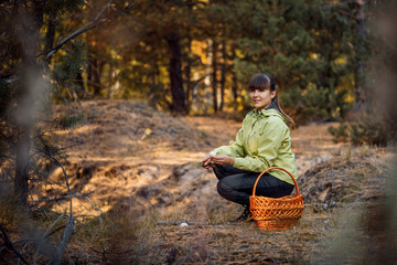 Beautiful girl in the autumn forest to gather mushrooms. Stay in the fresh air.