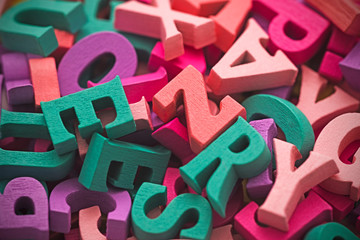 Pile of colorful painted wooden letters. Typography background composition. 