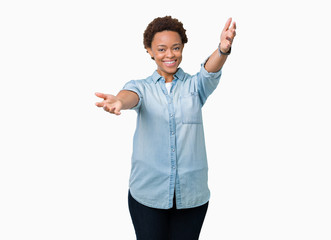 Young beautiful african american woman over isolated background looking at the camera smiling with open arms for hug. Cheerful expression embracing happiness.