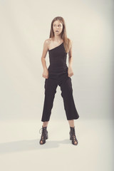 Fashionable girl in light tones in studio. Woman with unflappable face. Lifestyle concept in fashion world. Female in suit