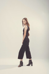 Fashionable girl in light tones in studio. Woman with unflappable face. Lifestyle concept in fashion world. Female in suit