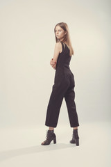 Fashionable girl in light tones in studio. Woman with unflappable face. Lifestyle concept in fashion world. Female in suit