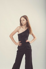 Fototapeta premium Fashionable girl in light tones in studio. Woman with unflappable face. Lifestyle concept in fashion world. Female in suit
