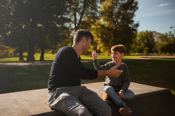 Hihg five - father and son in skate park