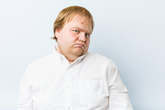 Young authentic redhead fat man confused, feels doubtful and unsure.