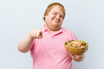 Caucasian crazy blond fat man holding a salad bowl