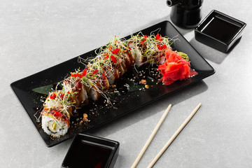 Philadelphia roll sushi with eel, avocado, cream cheese and caviar. Sushi menu. On dark stone plate in white background. Traditional japanese seafood, healthy food concept. Horizontal photo.