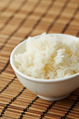 Bowl of rice on bamboo background 