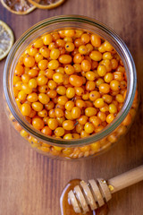 Fresh sea buckthorn in glass with honey.