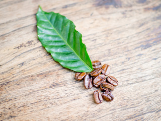 Coffee beans on the wooden table, ready to give freshness and alongside the businessman