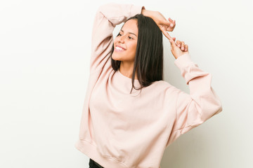 Young cute hispanic teenager woman stretching arms, relaxed position.