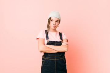 Hispter teenager woman frowning face in displeasure, keeps arms folded.