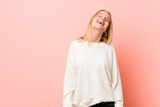 Young blonde teenager woman relaxed and happy laughing, neck stretched showing teeth.