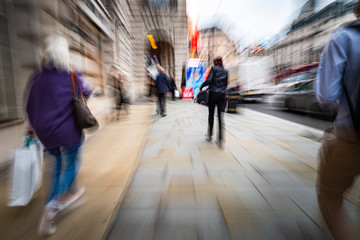 Motion blurred people walking on shopping street