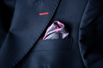 Handkerchief in a black suit pocket.Beautifully clothed pubs in a robe pocket.