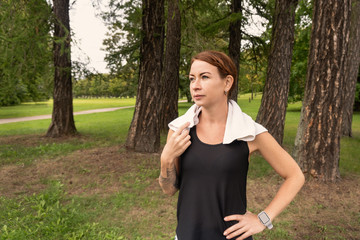 Fototapeta premium Beautiful and athletic girl with clothes for sport looking aside doing fitness in park
