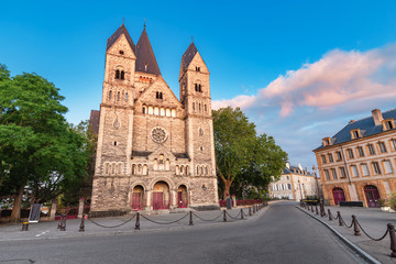 Fototapeta na wymiar Travel to Metz - the capital of the Moselle region, France. The city street leads to the ancient Temple Neuf Church during the sunrise