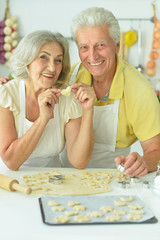 Portrait of senior couple baking in the kitchen at home