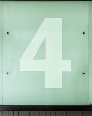 Obraz premium The number four, 4, on a glass wall.