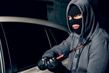 male thief is going to open the car door with a crowbar.