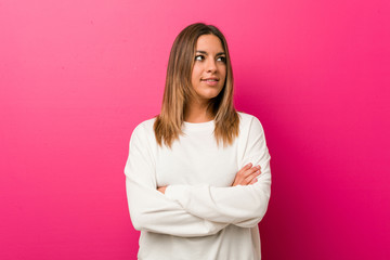 Fototapeta premium Young authentic charismatic real people woman against a wall smiling confident with crossed arms.