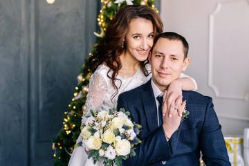 Beautiful wedding couple. Winter wedding of the groom in a beautiful suit and the bride in a beautiful wedding dress. Winter photo shoot newlyweds.